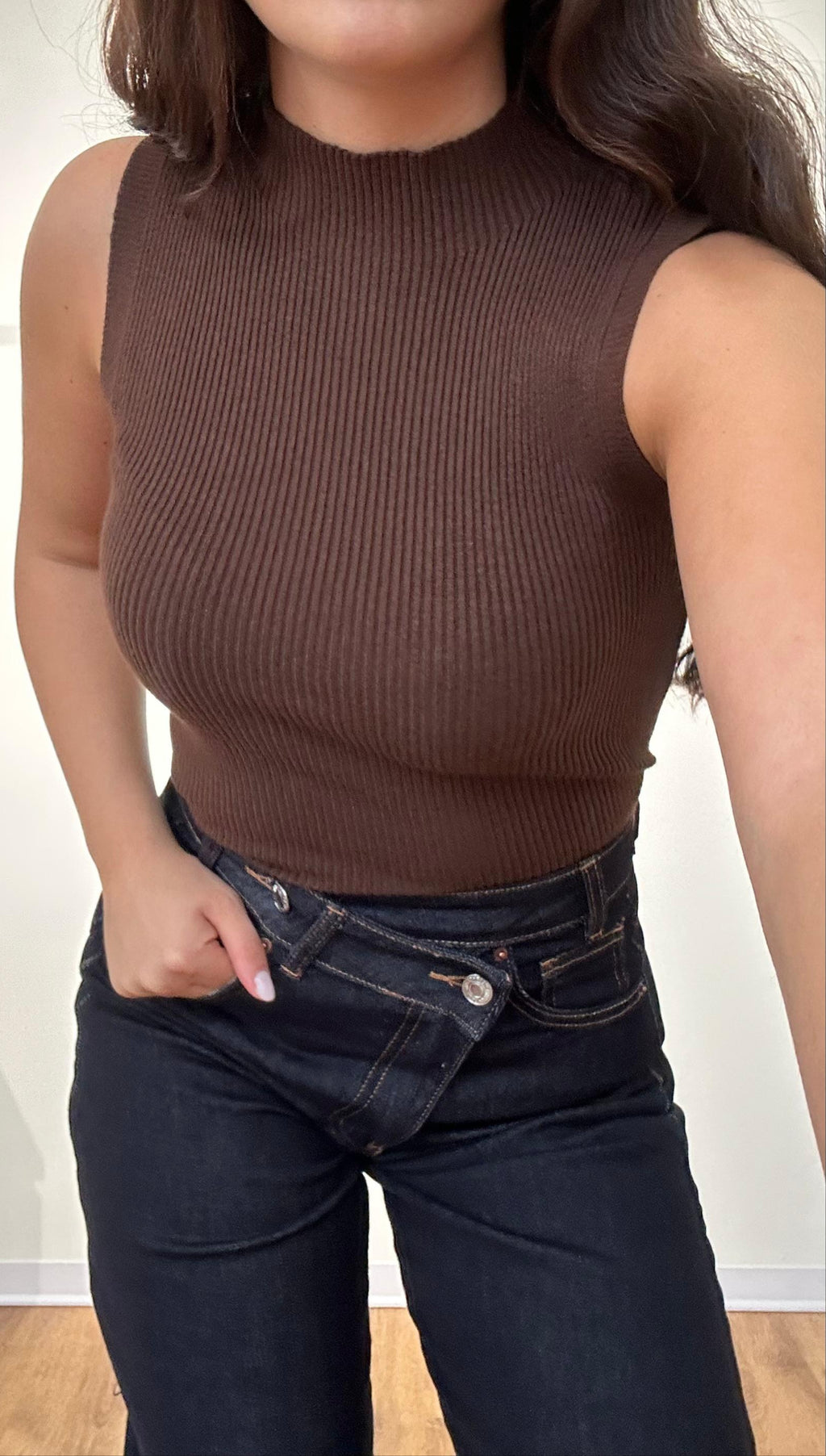Donna con top smanicato marrone a costine e jeans vita alta, stile streetwear casual
