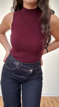 Canotta smanicata bordeaux a costine donna, abbinata a jeans vita alta scuri, outfit streetwear casual
